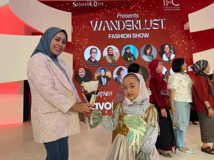 Ibunda Aisyah, ira Sutiara memberikan bunga kepada putrinya usai mengikuti fashion show - Foto: Henri Lukmanul Hakim