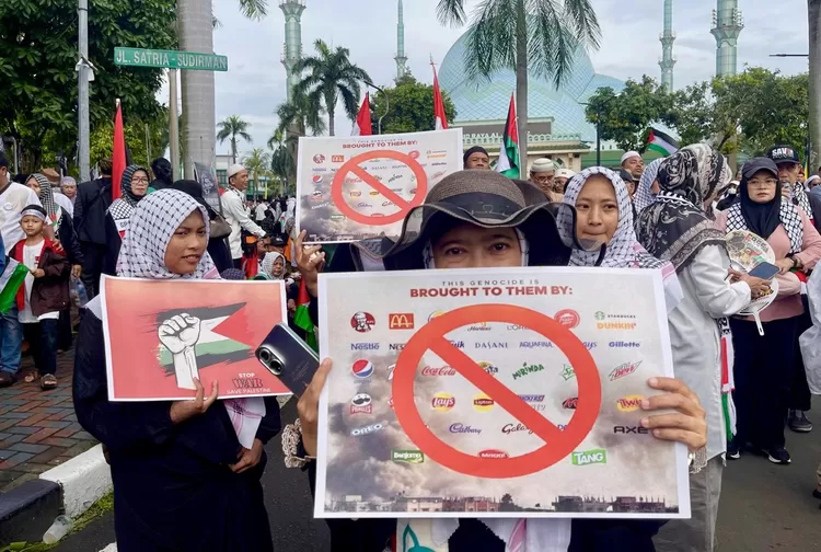 Peserta aksi Peduli Palestina membawa poster bergambar produk-produk Israel yang harus di boikot - Foto: Henri Lukmanul Hakim
