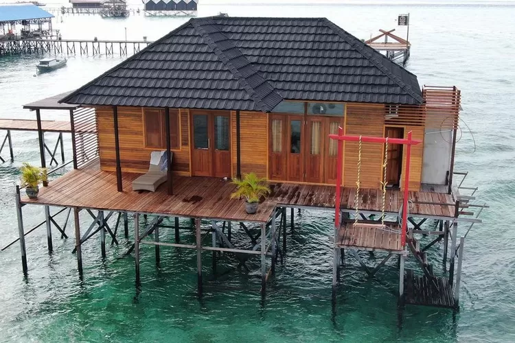 Potret kamar hotel Derawan Fisheries Cottages dengan background keindahan alam Pulau Derawan. (Instagram @derawanfisheries)