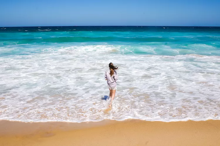 Wanita berdiri di pantai (Tangkapan layar Pexels @WendyWei)