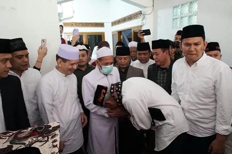 Ganjar Pranowo saat mencium tangan KH Tubagus Ahmad Syadzili Wasi, di Banten, Minggu (28/5/23). (Ist)