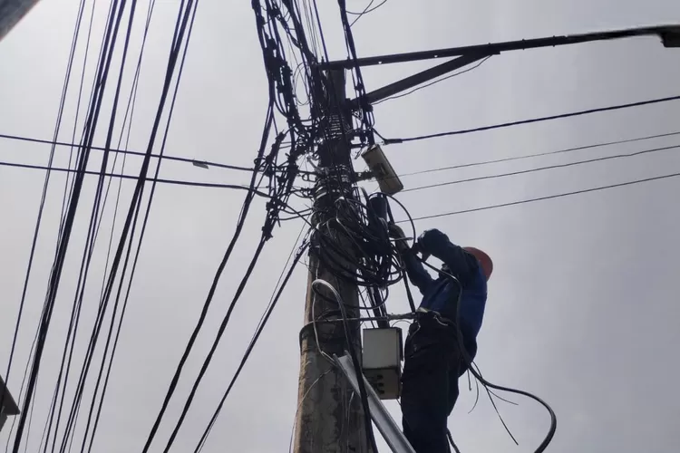 Petugas PLN Icon Plus sedang merapikan kabel fiber optik di Kota Bandung.