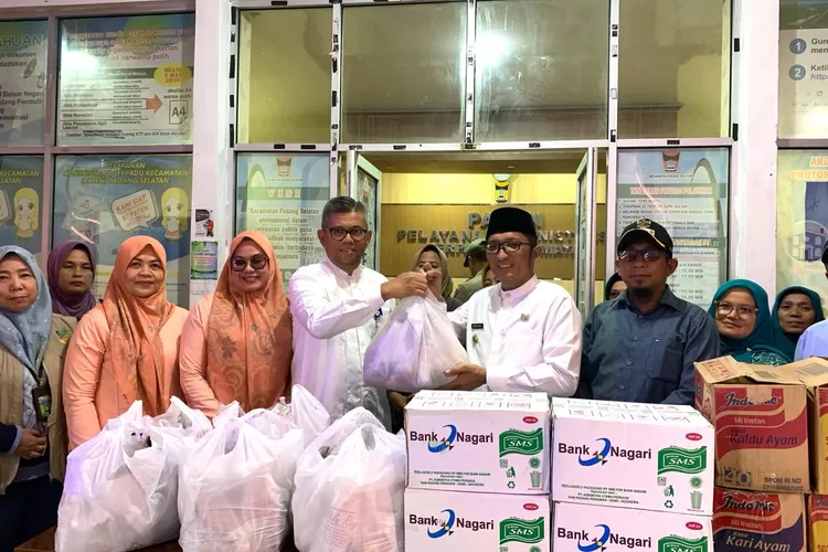 Pemimpin Bank Nagari Cabang Pasar Raya Hendri Masri menyerahkan bantuan untuk korban banjir kepada Wali Kota Padang Hendri Septa, di Kantor Camat Padang Selatan, Jumat (8/3). IST