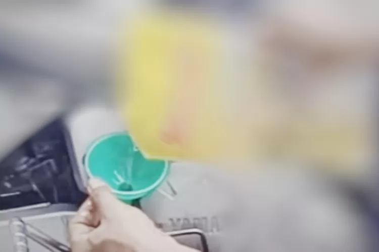 YouTuber ini saat menuangkan minyak goreng bermerek ke dalam tangki oli sepeda motornya. Foto: Tangkapan layar YT.