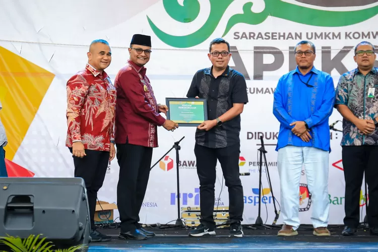 Pj Wali Kota Lhokseumawe memberikan piagam penghargaan kepada Pemko Medan yang diwakili Kabid Koperasi dan UKM Anwar Syarif. (Realitasonline.id/kominfo)