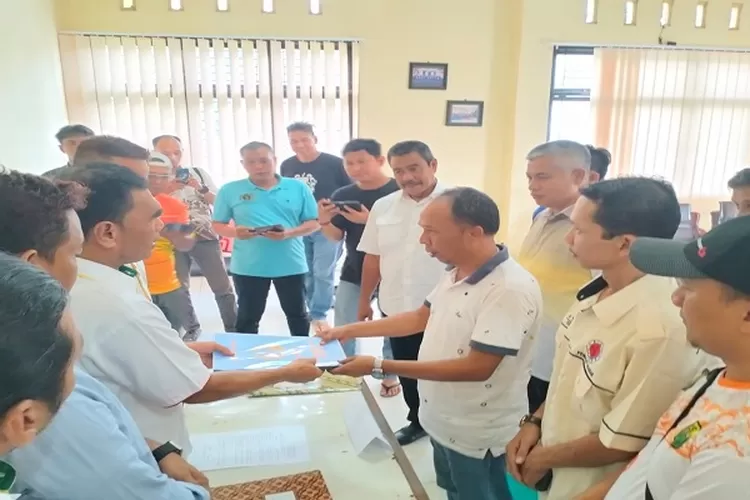 Harris saat menyerahkan berkas pendaftaran kepada ketua penjaringan Taufik dikantor KONI Asahan  (Realitasonline.id/HS)