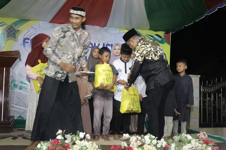 Mukhlis Takabeya (kanan) ketika menyerahkan paket bantuan dan uang tunai (Realitasonline.id/aj)