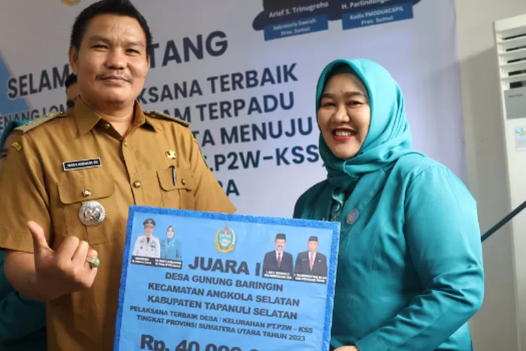 Kades Gunung Baringin Desa Gunung Baringin, Kecamatan Angkola Selatan, Tapsel Iran Soleh Harahap, SH didampingi Ketua TP PKK Desa Gunung Baringin, Nuazizah Iran Soleh Ritonga, menerima uang pembinaan atas raihan Juara I pada lomba Desa Binaan kategori PTP2WKSS tingkat Provsu tahun 2023, di Kantor TP