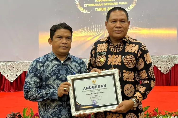 Pj Bupati Abdya, H Darmansah didampingi Kepala Dinas Komunikasi Informasi dan Persandian Ubai Rizal ST menerima penghargaan keterbukaan informasi publik di Banda Aceh, Rabu (06/12) (Realitasonline.id/kominfo)