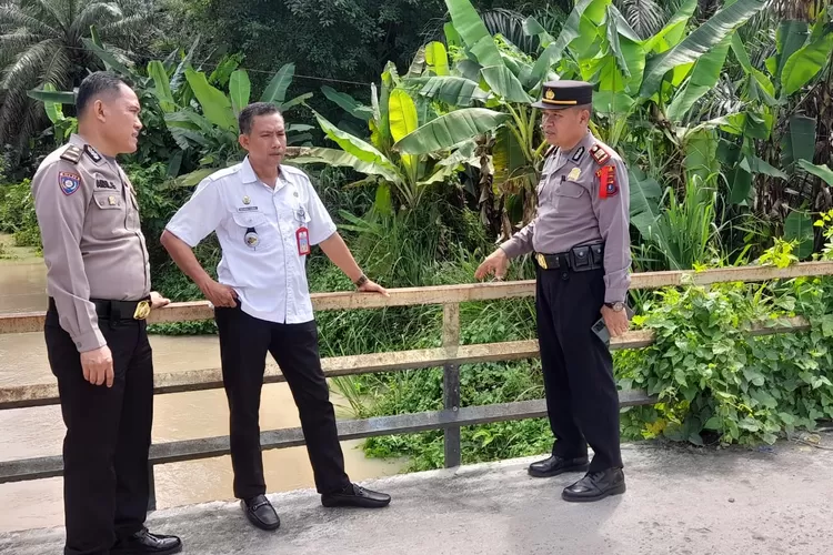  PANTAU : Kapolsek Lima Puluh, AKP Tukkar L. Simamora SH MHpantau keadaan sungai di Desa Empat Negeri.   (Realitasonline/H.Guntur Sinaga)