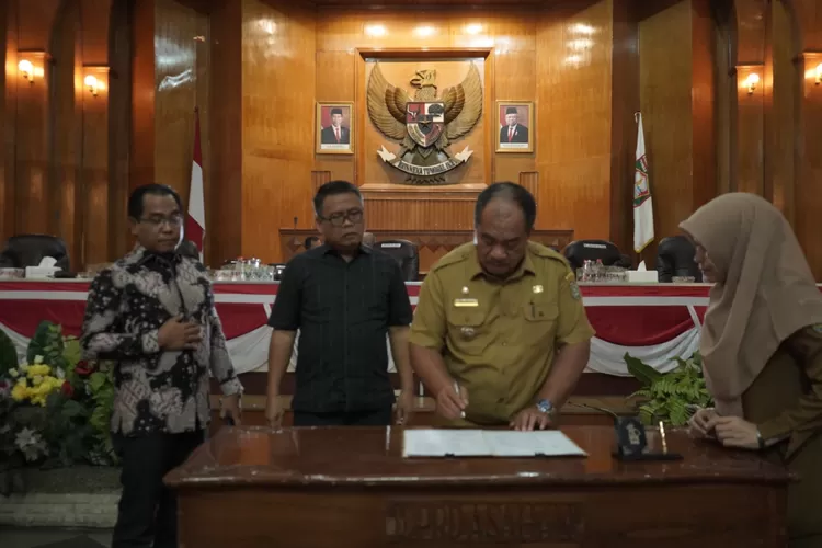 Wakil bupati Asahan saat menandatangani keputusan bersama antara DPRD dan Pemkab Asahan atas dua ranperda menjadi perda pada rapat paripurna dewan terbaru (Realitasonline.id/HS)