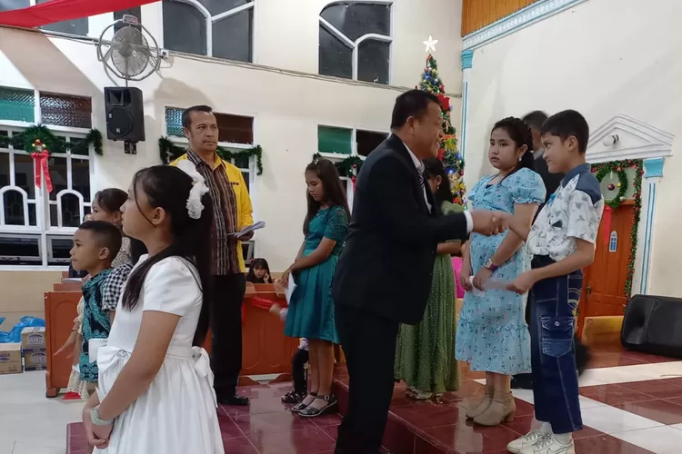 SERAHKAN: Siswa berprestasi terima bantuan dari Yayasan Peduli Pendidikan Partonabonasi diserahkan ketua umum Oloan Hutabalian.   (Realitasonline.id/MN)