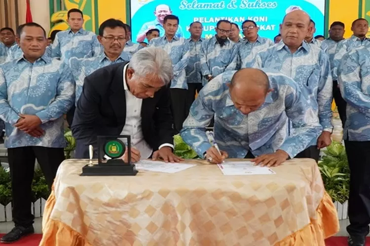 Ketua KONI Langkat Syah Afandin dan Ketua KONI Sumut John Ismadi Lubis menandatangani berita acara pelantikan (Realitasonline.id/zul)