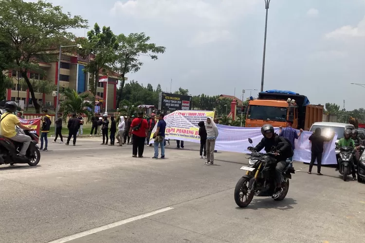 Puluhan peserta PPPK Kabupaten Langkat membentangkan spanduk menutup jalan di depan Mapolda Sumut saat gelar aksi demo, Rabu (13/3/2024).