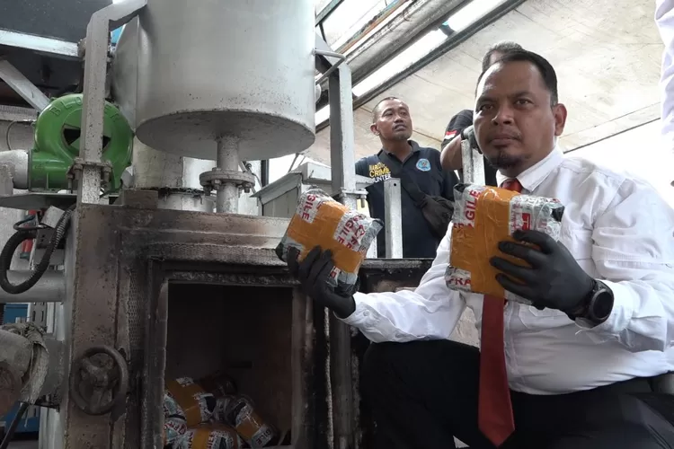 Kasat Narkoba Polrestabes Medan AKBP Jhon Sitepu memusnahkan sabu dengan cara dibakar ke dalam mesin incinerator, di Mapolrestabes, Senin (25/3/2024)