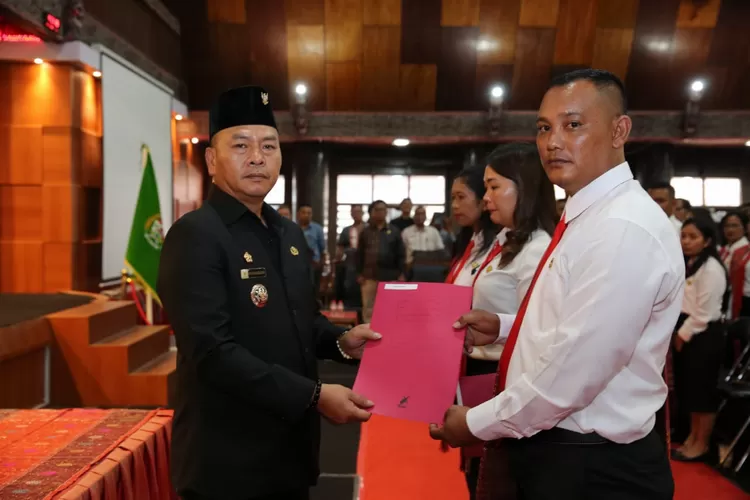 Bupati Taput Nikson Nababan saat menyerahkan SK pengangkatan calon PPPK dan perpanjangan kontrak PPPK di Sopo Partukkoan di Tarutung, Jumat 19 April 2024. (Realitasonline id/ AS)