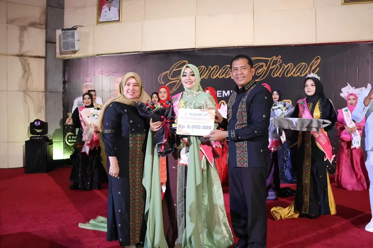 Kepala Dinas Pariwisata Saftar Harahap menyerahkan hadiah dan penghargaan kepada pemenang Putri Pariwisata Tapsel 2024 pada grand final di Gedung Serba Guna, Komplek Perkantoran Pemerintahan Tapsel Jalan Prof Lafran Pane, Sipirok, kemarin.(Realitasonline.id/ RI)