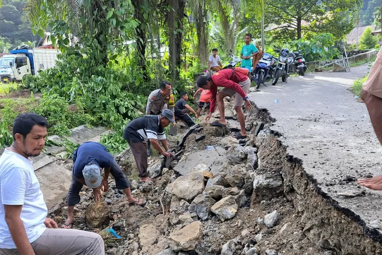 Bhabinkamtibmas Polsek Tapaktuan Bersama Warga bergotong royong Perbaiki Jalan Terdampak Longsor.(realitasonline.id/zul)