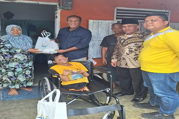 Region Head PTPN1 Regional 1 Didik Prasetyo (baju biru) menyerahkan kursi roda dan sembako kepada Nasib dan diterima ibunya Sriwati  (Realitasonline.id/zul)