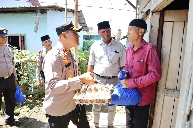Kapolres Padangsidimpuan AKBP. Dudung Setyawan didampingi Kepling IV Kelurahan Bincar Mhd. Amin Harahap menyerahkan bantuan sembako kepada warga kurang mampu dalam rangka Jumat Berkah  (Realitasonline.id/Riswandy)