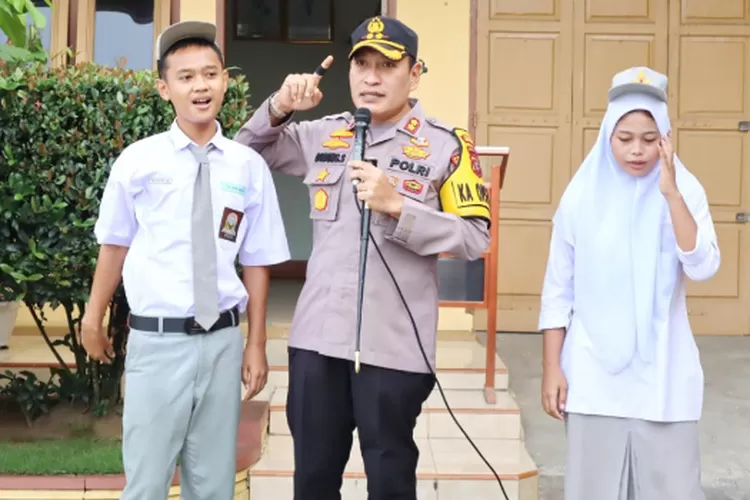 Kapolres Padangsidimpuan AKBP Dudung Setyawan memberi motivasi kepada seorang siswi, usai memimpin upacara di lapangan upacara SMK Panca Darma Padangsidimpuan Jalan Tapian Nauli Kelurahan Ujungpadang Kecamatan Padangsidimpuan Selatan Kota Padangsidimpuan, Senin (10/6/2024).(Realitasonline.id/ RI)
