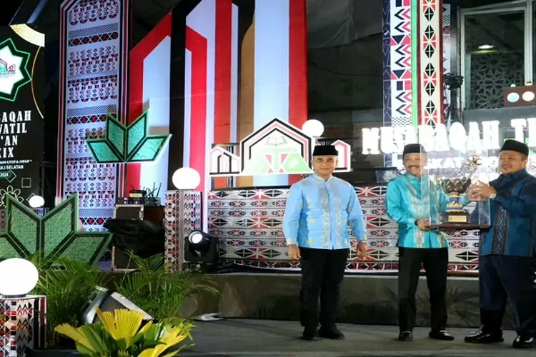 Sekdaprovsu Arief S Trinugroho, menyerahkan thropy bergilir kepada Bupati Tapsel Dolly Pasaribu, pada pembukaan MTQ ke 39 Tingkat Provsu tahun 2024 di Sipirok Kabupaten Tapsel  (Realitasonline.id/Riswandy)