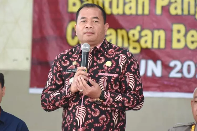Pj Wali Kota Padangsidimpuan, Timur Tumanggor, memberi sambutan pada penyaluran bantuan pangan cadangan beras pemerintah untuk bulan Juni tahun 2024 di Gedung Adam Malik Kota Padangsidimpuan Kamis (4/7/2024).(Realitasonline.id/ RI)