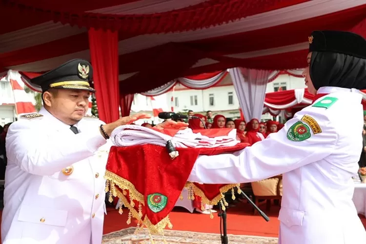 Bupati Tapsel Dolly Pasaribu menyerahkan bendera merah putih kepada personil Paskibra untuk dikibarkan pada upacara detik-detik proklamasi kemerdekaan RI ke 79 tahun 2024&nbsp;  (Realitasonline.id/Riswandy)