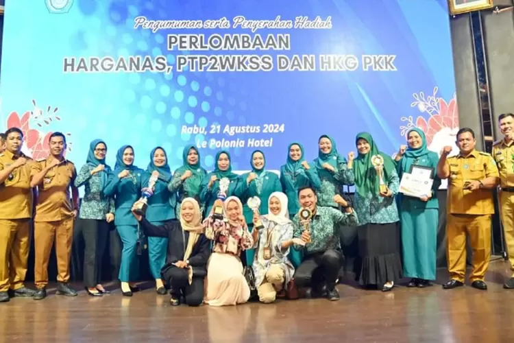 Ketua TP PKK Kota Padangsidimpuan Boya Timur Tumanggor menerima penghargaan dari Pj Gubsu Agus Fatoni dalam dalam perlombaan Harganas, PTP2WKSS dan HKG-PKK Tingkat Provsu, di Hotel Le Polonia, Medan, Rabu (21/8/2024).(Realitasonline.id/ Ist)