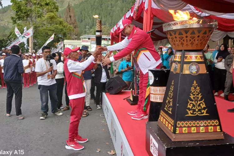 Pj. Bupati Aceh Tengah, Subhandy menerima obor Api PON ke XXI Aceh-Sumut dari Karma Aslia Tarigan mantan atlit Pencak Silat. (Realitasonline.id /ADI)