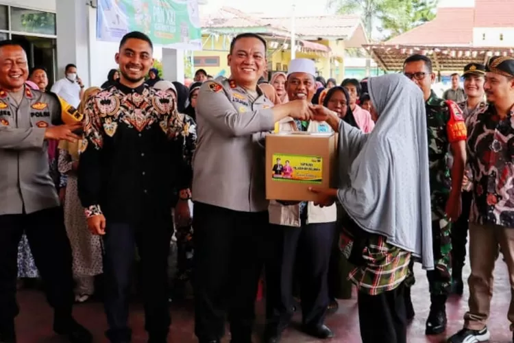 Kapolres Pelabuhan Belawan menyerahkan bantuan sembako kepada salah seorang warga dalam kegiatan Jumat Curhat dan Jumat Berkah di Kantor Camat Belawan, Jumat (6/9/2024)