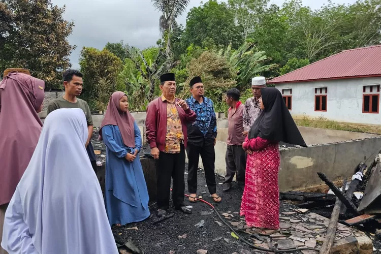 Syahrul Pasaribu (tengah) mewakili Tim BAGUSI dan YHHP mendatangi dan menyerahkan santunan kepada korban kebakaran di Desa Biru ( Realitasonline.id/Riswandy)