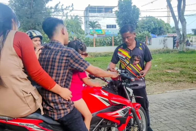 Seorang petugas parkir saat memeriksa STNK sepeda motor pengunjung Taman Cadika Medan Johor, Sabtu (16/11/2024).