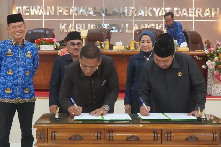 Sekretaris Daerah Kabupaten Langkat Amril, menandatangani berita acara pengesahan ranperda APBD 2025 pada rapat paripurna DPRD Langkat (Realitasonline.id/AA)