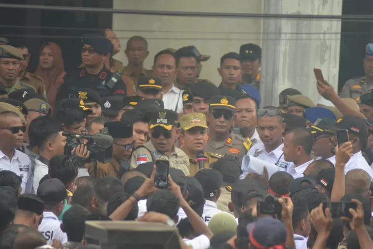 Pj Bupati Abdya, Sunawardi (topi kuning) saat menghadapi ribuan pengunjuk rasa dari Keuchik dan Aparatur Desa di Kantor BPKD setempat, Senin (9/12/2024).