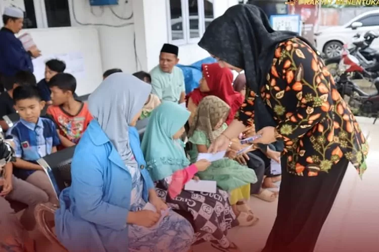 Sekretaris KPU Kabupaten Tapsel Riski Hastuti Ritonga menyerahkan santunan kepada anak yatim di lingkungan kantor KPU Tapsel ( Realitasonline.id/Riswandy)