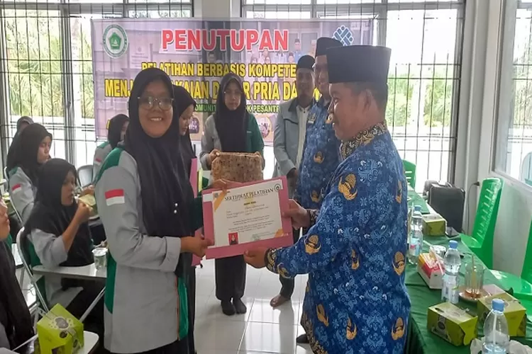 Pemberian sertifikat secara simbolis kepada peserta pelatihan berbasis kompetensi menjahit pakaian pria dan wanita angkatan ke V di BLKK Ponpes Rahul Islam (, Realitasonline.id/SS)