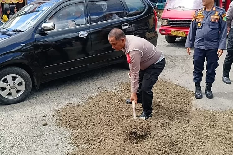 Personil Polres Padangsidimpuan bekerja sama dengan personil Dinhub dan Dinas PU Bina Marga UPT Padangsidimpuan, melakukan penimbunan jalan berlobang dengan material pasir di sejumlah ruas jalan Kota Padangsidimpuan  (Realitasonline.id/Riswandy)