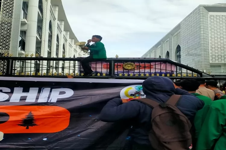 Aksi mahasiswa mendobrak gerbang gedung DPRD Sumut dengan menaiki dan duduk di atas pagar seraya berorasi menuntut DPR segera mengesahkan RUU perampasan aset (Realitasonline.id/Dok)