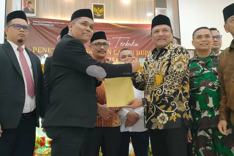 Ketua KIP Bireuen,Saiful Hadi ( tiga kiri) menyerahkan berkas penerapan calon Bupati dan Wakil Bupati Bireuen terpilih kepada Bupati Bireuen terpilih H Mukhlis (empat kiri)  (Realitasonline.id/ RZ)