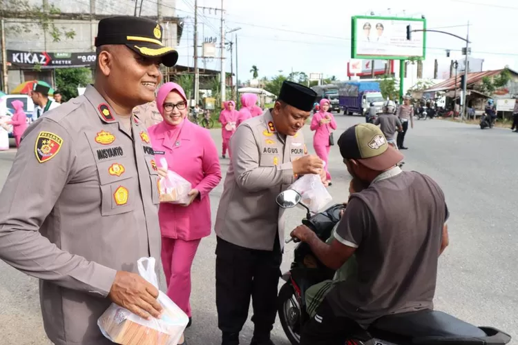 Kapolres Abdya AKBP Agus Sulistianto (kanan) didampingi Ketua Bhayangkari dan Wakapolres Kompol Misyanto membagikan ratusan takjil berbuka puasa di bulan suci Ramadhan, Sabtu (8/3/2025)