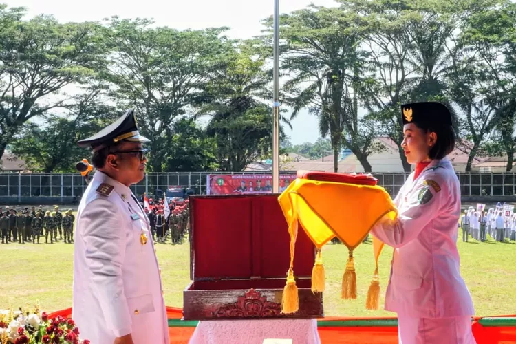 Wali Kota Padangsidimpuan, Letnan Dalimunthe menyerahkan bendera merah putih kepada pembawa baki untuk dikibarkan, pada detik-detik Proklamasi Kemerdekaan Republik Indonesia ke 80 di Stadion H.M. Nurdin Kota Padangsidimpuan, Minggu (17/8/2025).(Foto : Realitasonline / Riswandy)