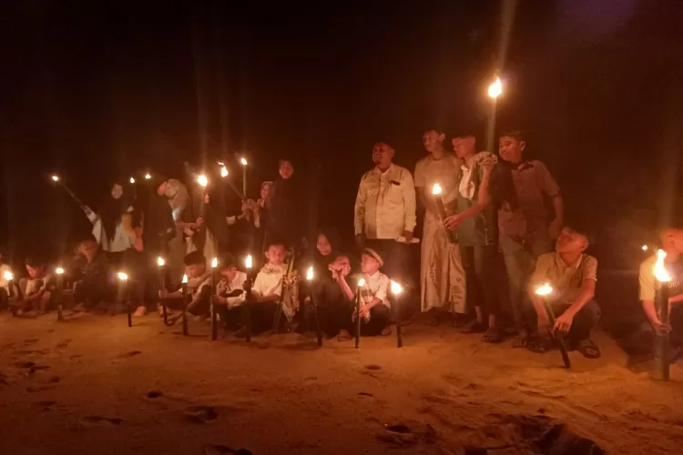 Sejumlah santri di Balai Pengajian Nurul Quran, Desa Mesjid, Kecamatan Tangan-Tangan, Kabupaten Abdya bersama warga membuang obor ke lautan di pesisir pantai Padang Kawa dalam rangka memperingati malam tolak bala atau Rabu terakhir di bulan Safar, Selasa (19/8/2025) malam.
