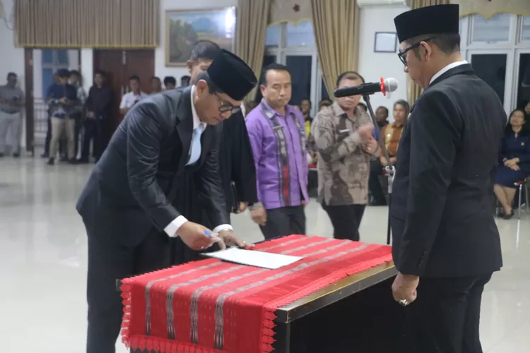 Bupati Taput Dr. Jonius Taripar Hutabarat, MSi saat menyaksikan Sekda Drs.Henry Maraden Masista Sitompul , MSi menandatangani pakta integritas usai dilantik. (Realitasonline.id/AS)