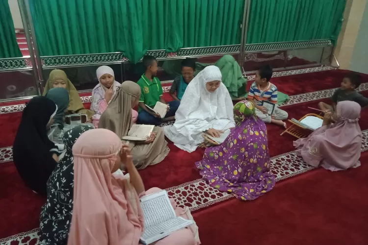 Sosok ibu Deswita ditengah-tengah muridnya saat membimbing membaca Al Qur'an pada setiap maghrib mengaji di Masjid Al Muawannah Medan Sunggal.