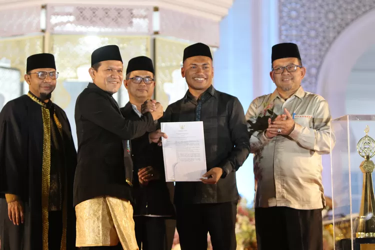 Wakil Gubernur Aceh Fadhlullah menyerahkan surat penetapan tuan rumah pelaksanaan MTQ Aceh ke-38 tahun 2027 kepada Bupati Abdya Safaruddin pada malam penutupan MTQ Aceh ke-37 di kabupaten Pidie Jaya, Jumat (7/11/2025) malam