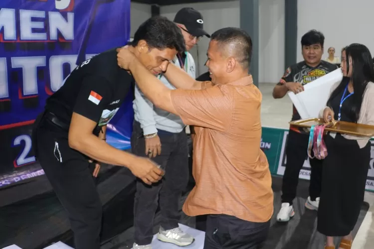 Sekda Junaedi Sitanggang mengalungkan piagam kepada juara (Realitasonline/RH)