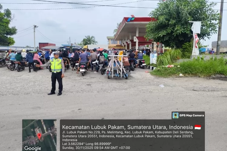 Personil sat lantas Polresta Deli Serdang sedang mengatur arus lalu lintas dari kemacetan masyarakat yang antri untuk mengisi BBM di SPBU