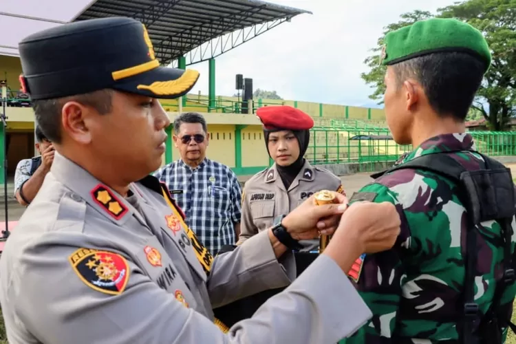 Kapolres Padangsidimpuan AKBP Wira Prayatna, srmatkan pira operasi kepada perwakilan personil pada Apel Gelar Pasukan Operasi Kepolisian Terpusat &ldquo;Lilin Toba 2025&rdquo;, dilaksanakan di Stadion H.M. Nurdin, Kota Padangsidimpuan, Jumat (19/12/2025). (Foto : Realitasonline / Riseandy)