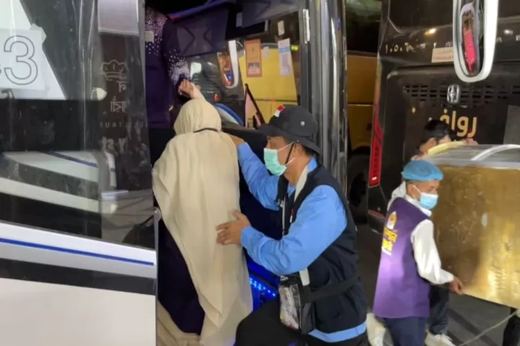 Momen jemaah haji yang akan masuk ke dalam bus dibantu oleh petugas (Kemenang)